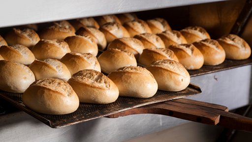 Freshly baked rolls being removed from oven.