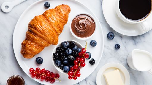 Croissant with fruit and coffee.
