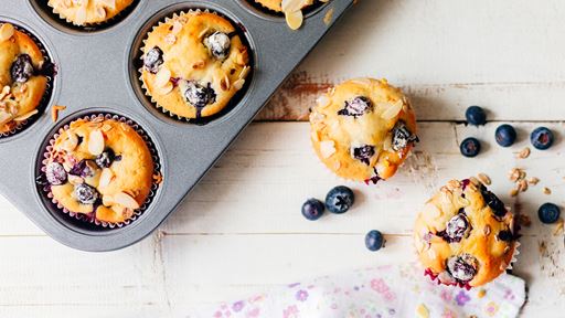 Blueberry muffins in pan and on table. 