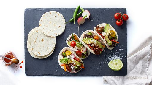 Tortillas and tacos on prep board. 