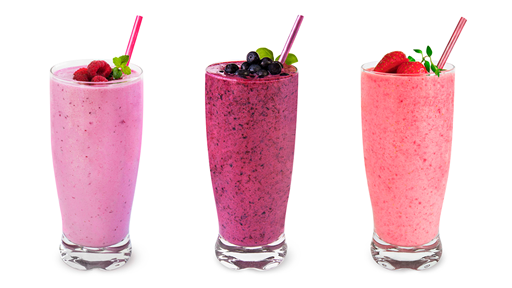 Three different smoothies with fresh berries  on top in tall clear glasses.