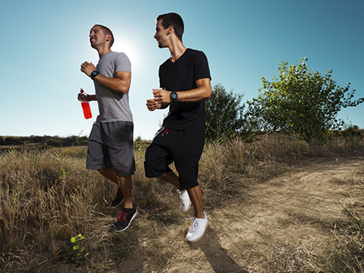 Two smiling men jogging.