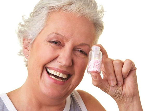 Older lady laughing about pills. 