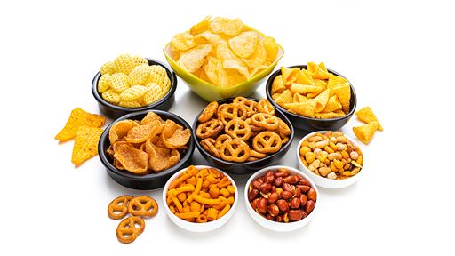 Eight different sized and colored ramekins filled with various snacks such as pretzels, potato chips and other snacking foods.