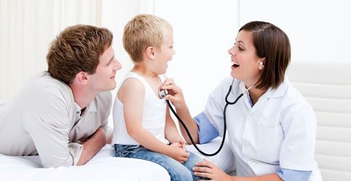 Doctor checking young boy with stethoscope. 