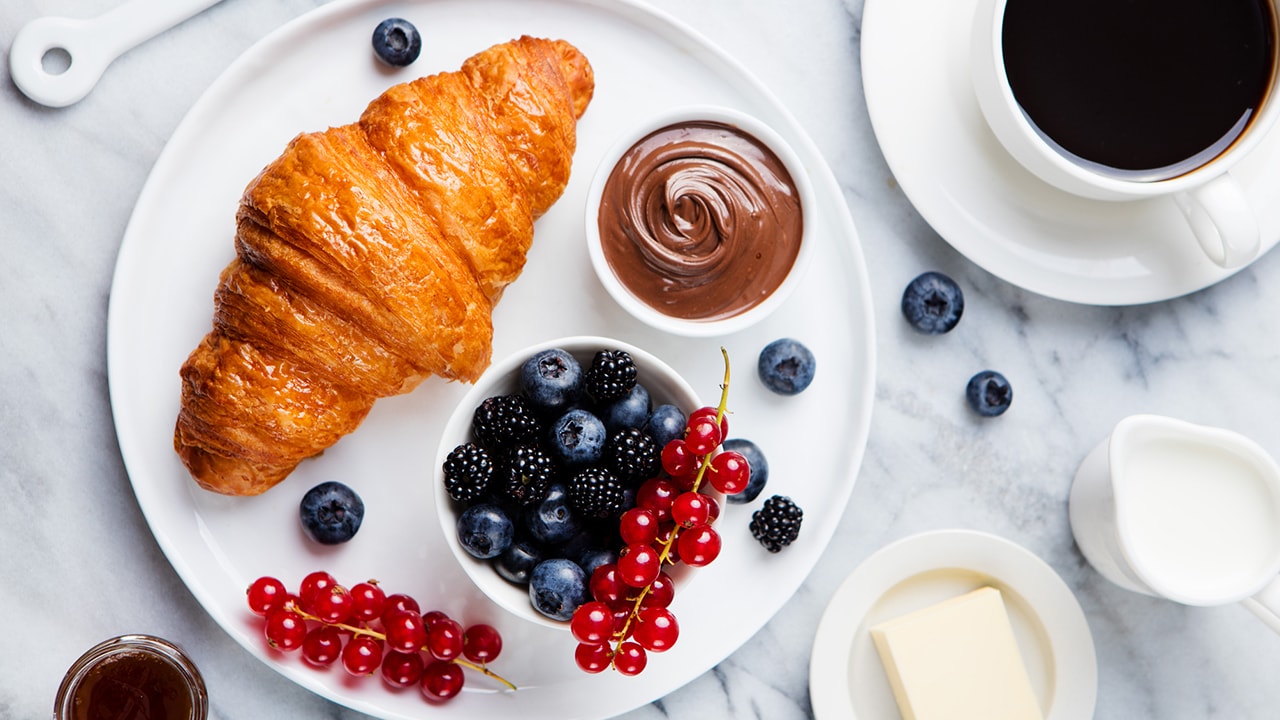Croissant with fruit and coffee.