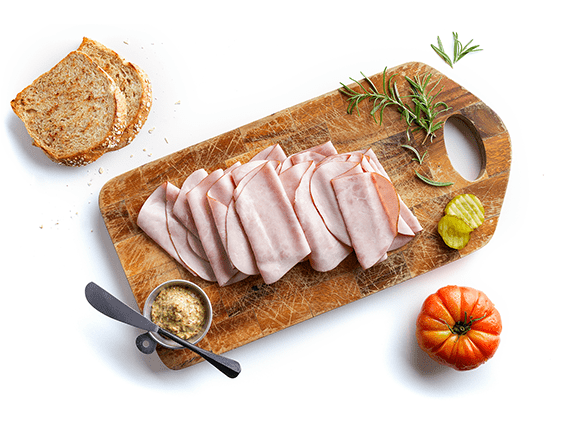 Cooked sliced deli meat on cutting board used to demonstrate Listeria growth prediction and food safety modeling with Corbion’s Listeria Control Model.