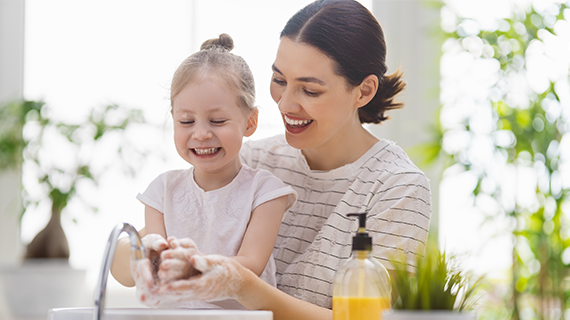 Mother and daughter washing hands.