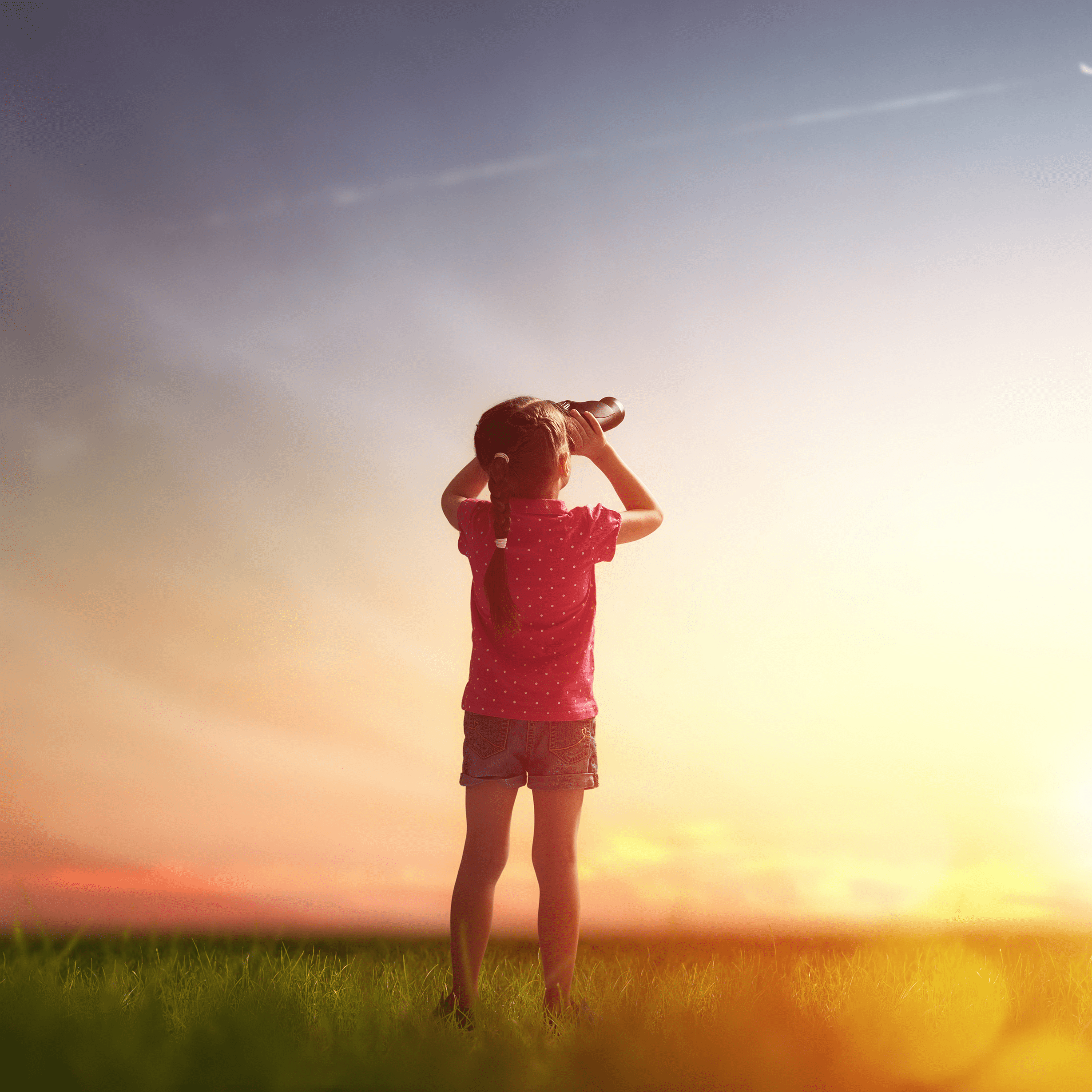 Girl with binoculars in field