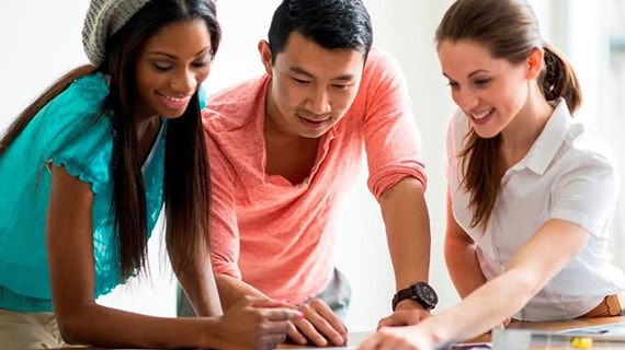 Group of people looking at images on a table.