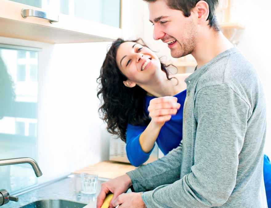 Smiling couple cleaning together.