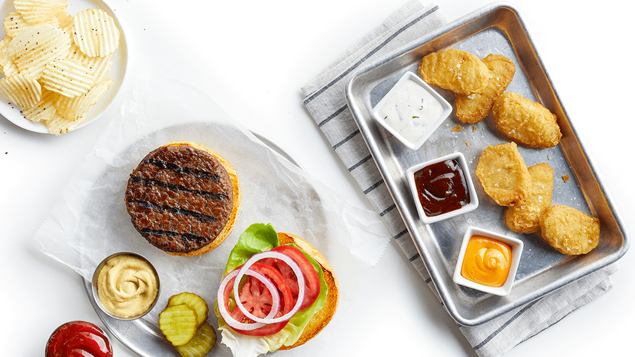Plated plant based meats with set up and condiments. 