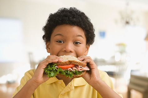 Kid eating sandwich.